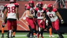 Calgary Stampeders' Zack Williams (67), Malik Henry (82) and Sean McEwen (51) celebrate Henry's touchdown against the B.C. Lions during the second half of a CFL football game in Vancouver, on Friday, November 12, 2021. (THE CANADIAN PRESS/Darryl Dyck)