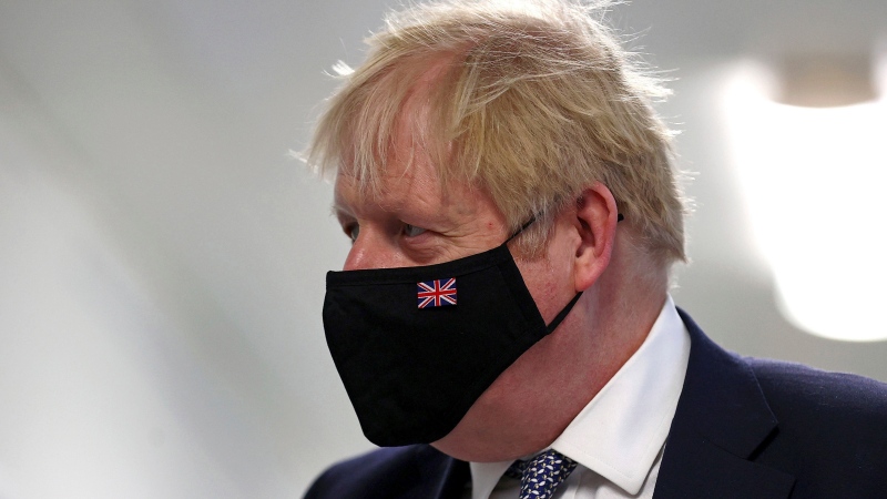 Britain's Prime Minister Boris Johnson wears a face mask, during a visit to Milton Keynes University Hospital in Buckinghamshire, England, Monday, Jan. 24, 2022. (Adrian Dennis/Pool Photo via AP) 
