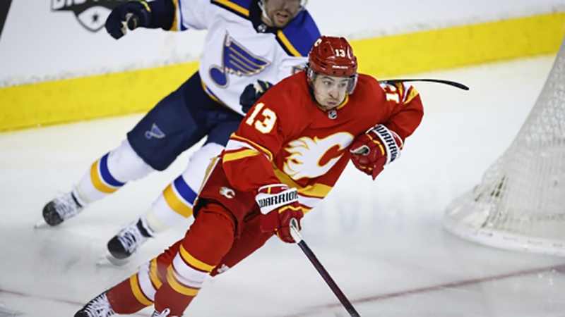 St. Louis Blues' David Perron, left, chases Calgary Flames' Johnny Gaudreau during second period NHL hockey action in Calgary, Alta., Monday, Jan. 24, 2022. THE CANADIAN PRESS/Jeff McIntosh