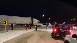 The convoy, protesting vaccine mandates for cross-border travel for truckers, headed out of the city on Highway 1 east Monday night. (Gareth DIllistone/CTV News)