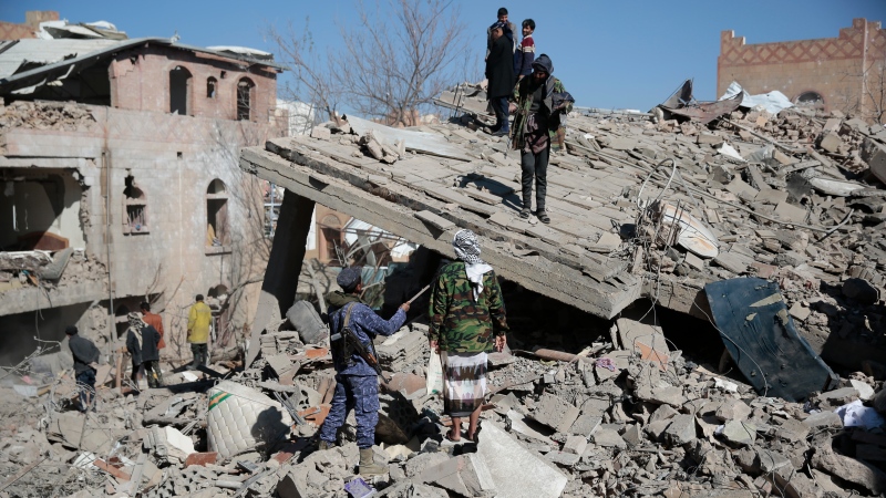 People inspect the wreckage of buildings that were damaged by Saudi-led coalition airstrikes, in Sanaa, Yemen, Tuesday, Jan. 18, 2022. (AP Photo/Hani Mohammed) 