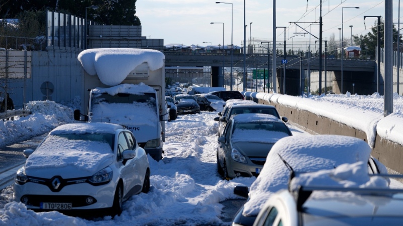 Stranded vehicles are covered with snow for three days along Attiki Odos tollway, linking Athens to the capital's international airport, on Jan. 26, 2022.  (Thanassis Stavrakis / AP) 