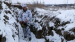 FILE - A serviceman stands holding his machine-gun in a trench on the territory controlled by pro-Russian militants at frontline with Ukrainian government forces in Slavyanoserbsk, Luhansk region, eastern Ukraine, Jan. 25, 2022. (Alexei Alexandrov / AP) 