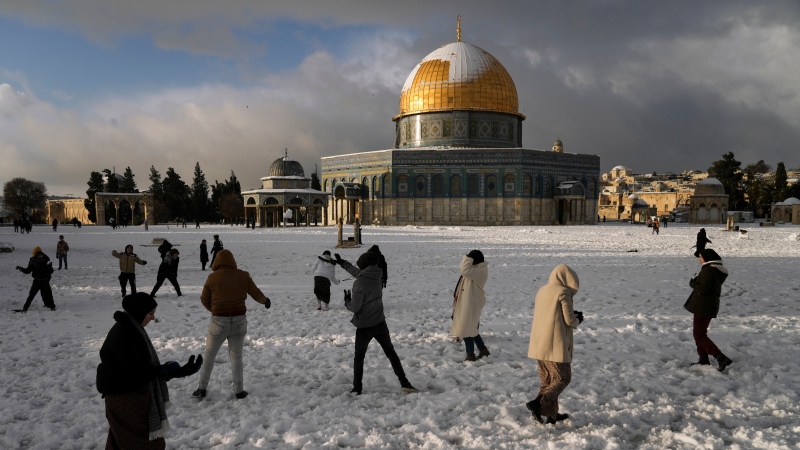 Palestinians enjoy the snow next to the Dome of the Rock Mosque in the Al Aqsa Mosque compound in Jerusalem Old City on Jan. 27, 2022. (AP Photo/Mahmoud Illean)