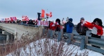 Supporters of a truck convoy headed for Ottawa line a bridge over Highway 401 in London, Ont. on Thursday, Jan. 27, 2022. (Reta Ismail / CTV News)