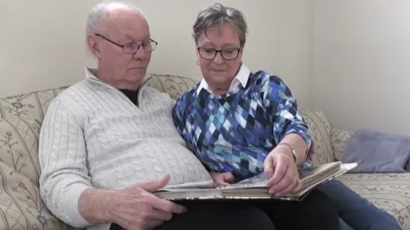 Alec and Janet Lockyer look at a photo album of their travels. (CTV News Kitchener)