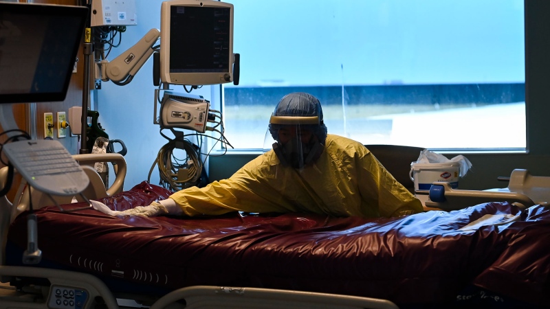 An essential worker thoroughly cleans a COVID-19 patient's room after being transferred out of the intensive care unit at the Humber River Hospital during the COVID-19 pandemic in Toronto on Tuesday, April 13, 2021. THE CANADIAN PRESS/Nathan Denette 
