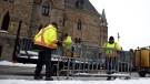 Public Works staff prepare fencing in front of Parliament Hill’s West Block in Ottawa, on Thursday, Jan. 27, 2022, before a cross-country convoy protesting a federal vaccine mandate for truckers is expected on Saturday. (Justin Tang/THE CANADIAN PRESS)