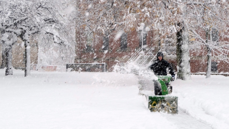 A man uses a snow blower in front of the Coles building in downtown Charlottetown on Nov. 30, 2016. (John Morris / THE CANADIAN PRESS)