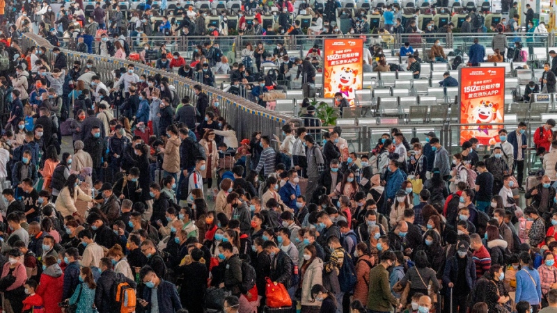 Travellers line up for trains at a station in Guangzhou, China, on Jan. 28, 2022. (Chinatopix via AP) 