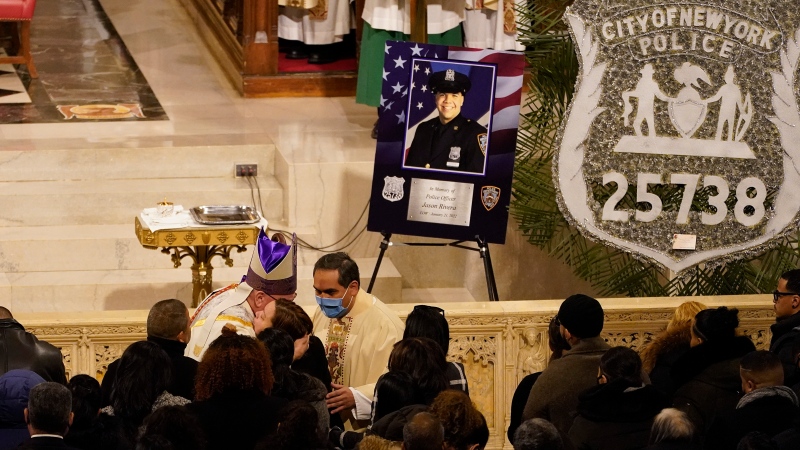 Cardinal Timothy Dolan, left, hugs family and friends of Officer Jason Rivera at the start of Rivera's funeral service inside St. Patrick's Cathedral, Friday, Jan. 28, 2022, in New York. (AP Photo/Mary Altaffer, POOL) 