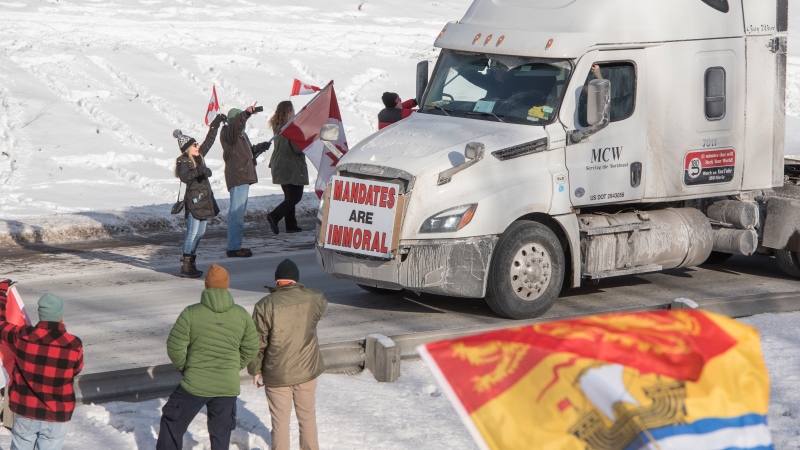Close to a thousand people lined the westbound lane of the Trans-Canada Highway at the Nevers Road overpass 10 minutes east of Fredericton in Waasis, New Brunswick on Thursday January 27, 2022. THE CANADIAN PRESS/Stephen MacGillivray 