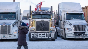 A person walks by a truck with a “Freedom’ on it before the departure of the trucks from Kingston to Ottawa, in Kingston, Ont., on Friday, Jan. 28, 2022. THE CANADIAN PRESS/Lars Hagberg 
