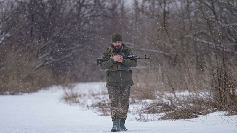 A Ukrainian serviceman holds his weapon while walking in a frontline village in the Luhansk area, eastern Ukraine, Friday, Jan. 28, 2022. (AP Photo/Vadim Ghirda) 