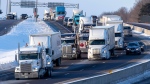 Trucks from the 'Freedom' convoy travel on Highway 401 headed eastbound in Kingston, Ont., headed for Ottawa, on Friday Jan. 28, 2022. THE CANADIAN PRESS/Lars Hagberg 