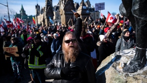 A person holds their hand to their heart during a singing of O Canada during a rally against COVID-19 restrictions on Parliament Hill, which began as a cross-country convoy protesting a federal vaccine mandate for truckers, in Ottawa on Sunday, Jan. 30, 2022. THE CANADIAN PRESS/Justin Tang 