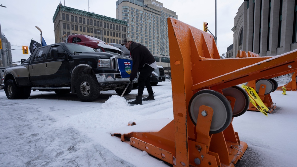 Freedom Convoy: A protester shovels snow