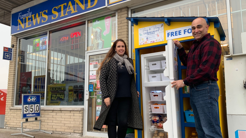Merola (left) and Saeid Tahamtan (right) stand in front of their community fridge where those who need extra food can grab some, located on 506 Days Rd, in Kingston, Ont. (Kimberley Johnson/CTV News Ottawa)