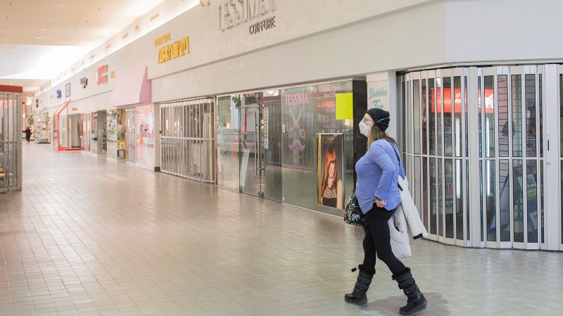 A woman walks by a closed store in a shopping mall in Montreal, Sunday, January 16, 2022, as the COVID-19 pandemic continues in Canada. (THE CANADIAN PRESS / Graham Hughes)