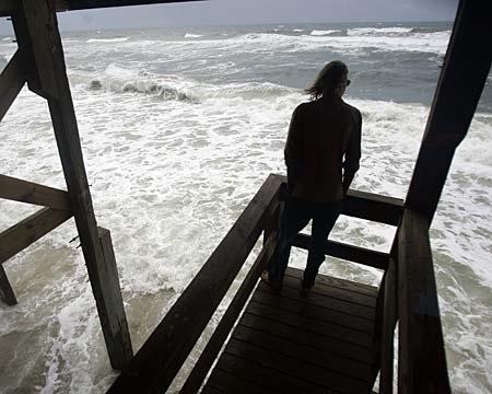 Yogi Harper watches from the deck of an ocean-front house at high-tide as tropical storm Gabrielle lurks offshore in Nags Head, N.C. on Sunday, Sept. 9, 2007. (AP Photo/Gerry Broome)