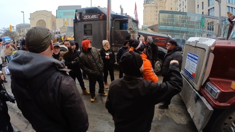 ByWard Market resident John Hennessy is surrounded by protesters as he stands in front of a truck on Sussex Drive on Friday, Feb. 11, 2022. (Graham RIchardson/CTV News Ottawa)