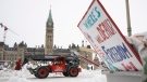 Machinery moves a concrete barricade past the Parliament buildings and a container of garbage from the Trucker protest which has occupied the streets of Ottawa, Sunday, February 20, 2022. (THE CANADIAN PRESS/Adrian Wyld)