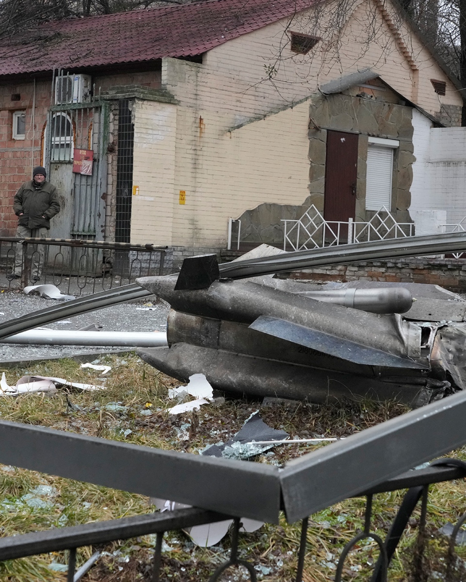 A man stands next to debris from Russian shelling