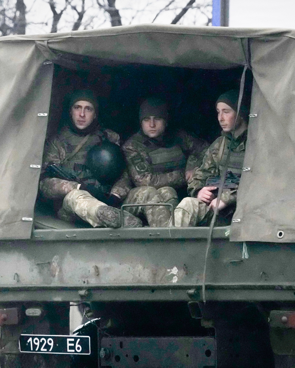 Ukrainian soldiers ride in a military vehicle