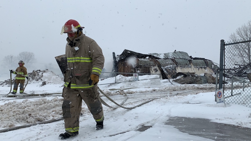 Firefighters monitor the burned out remains of a hangar at the Tyendinaga Mohawk Airport on Friday. (Kimberley Johnson/CTV News Ottawa)