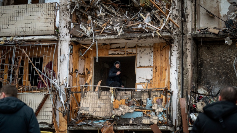 A man inspects the damage at a building following a rocket attack on the city of Kyiv, Ukraine, Friday, Feb. 25, 2022. (AP Photo/Emilio Morenatti) 