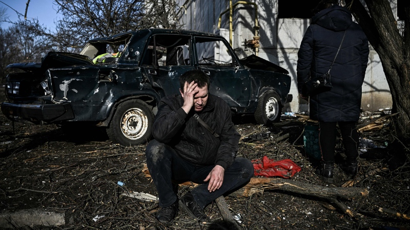 A man sits outside his destroyed building after bombings on the eastern Ukraine town of Chuguiv on Feb. 24, 2022. (Aris Messinis/AFP/Getty Images via CNN)
