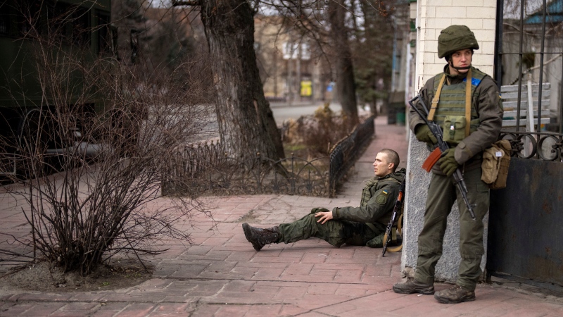 A Ukrainian soldier sits injured in cross fire inside the city of Kyiv, Ukraine, Friday, Feb. 25, 2022.  (AP Photo/Emilio Morenatti)