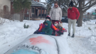 Olympians Cody Sorensen and Mike Evelyn, both from Ottawa, visit children in Wellington West that created a replica Team Canada bobsled during the Winter Games. (Jackie Perez/CTV News Ottawa)