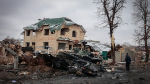 A man looks at the gutted remains of Russian military vehicles on a road in the town of Bucha, close to the capital Kyiv, Ukraine, Tuesday, March 1, 2022. Russia on Tuesday stepped up shelling of Kharkiv, Ukraine's second-largest city, pounding civilian targets there. (AP Photo/Serhii Nuzhnenko) 