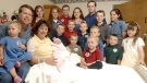 Michelle Duggar, left, is surrounded by her children and husband Jim Bob, second from left, after the birth of her 17th child in Rogers, Ark. in 2007. (AP / Beth Hall)