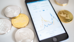 A phone and representations of cryptocurrencies are seen in this file photo.