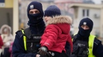 A police officer carries a young child arriving on a train originating from Odesa, Ukraine, at the station in Przemysl, Poland, Monday, March 7, 2022. (AP Photo/Czarek Sokolowski)