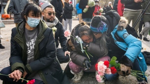 People comfort each other as they gather in memory of Elisape Pootoogook, Monday, November 22, 2021 in Montreal. The 61-year-old homeless woman was found dead on November 13 after being unable to find a shelter for the night. THE CANADIAN PRESS/Ryan Remiorz