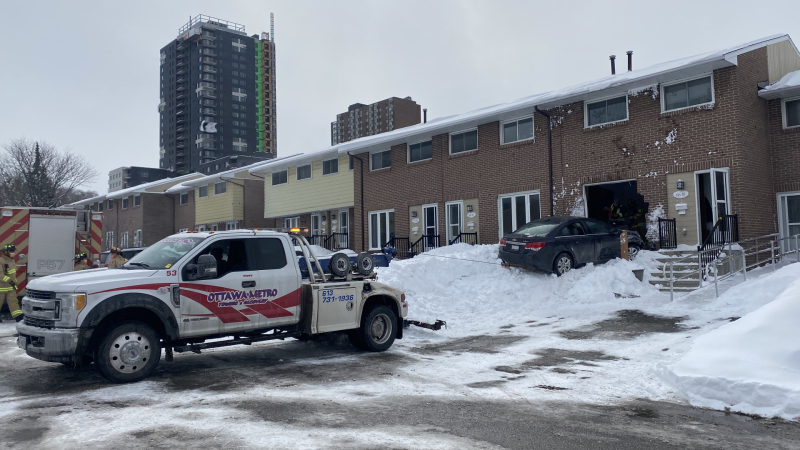 A tow truck removes a vehicle that had been driven through the front window of a Heney Street home in Ottawa, Saturday, March 12, 2022. (Colton Praill/CTV News Ottawa)