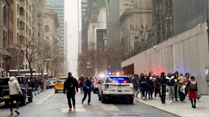 In this photo from a social media post by Scott Cowdrey, people are evacuated from the Museum of Modern Art where a stabbing occurred, Saturday, March 12, 2022, in New York. (Scott Cowdrey via AP)