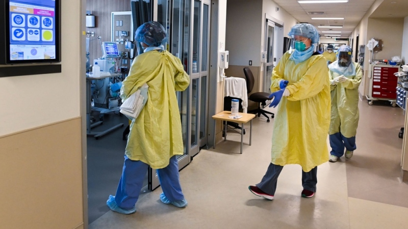 FILE - ICU health-care workers enter a negative pressure room to care for a COVID-19 patient on a ventilator at the Humber River Hospital during the COVID-19 pandemic in Toronto on Wednesday, December 9, 2020. THE CANADIAN PRESS/Nathan Denette 