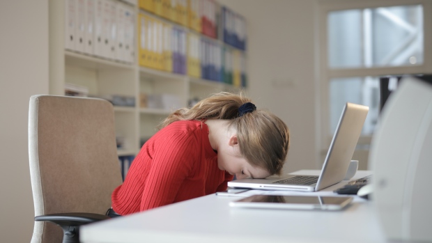 A woman puts her head down on a laptop computer in this undated file photo. (Andrea Piacquadio / Pexels)