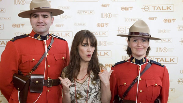 Feist poses with two Mounties as she arrives on the red carpet during the Juno Awards in Calgary Sunday, April 6, 2008. (THE CANADIAN PRESS/Larry Macdougal)