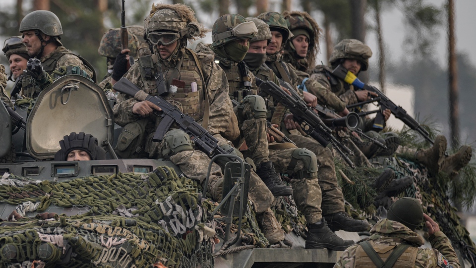 Ukrainian servicemen ride on armored transporter
