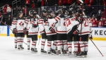 Canada celebrates their victory over Austria following third period IIHF World Junior Hockey Championship action in Edmonton on Tuesday, December 28, 2021. (THE CANADIAN PRESS/Jason Franson)