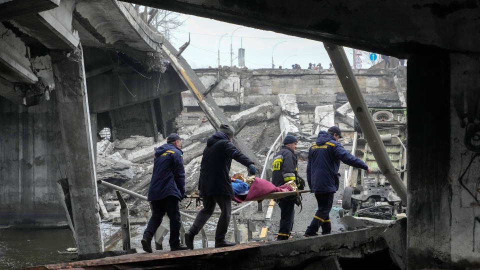 Ukrainian rescue workers carry woman Kyiv