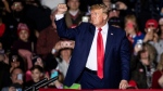 Former U.S. President Donald Trump waves at supporters after speaking at a rally at the Michigan Stars Sports Center in Washington Township, Mich., Saturday, April 2, 2022. (Junfu Han/Detroit Free Press via AP)
