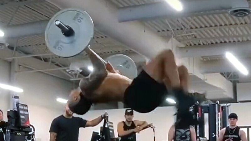 CFL player does a backflip while holding barbell