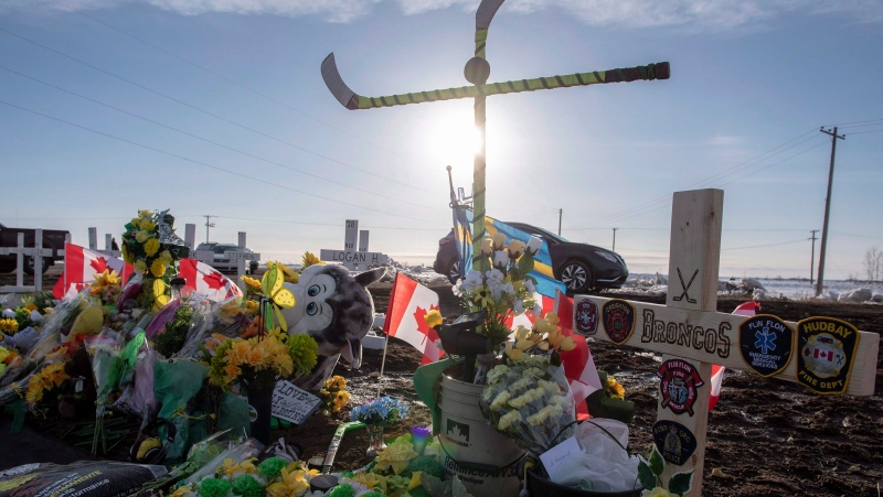 Hockey sticks, messages and other items continue to be added to a memorial at the intersection of a fatal bus crash that killed 16 members of the Humboldt Broncos hockey team last week near Tisdale, Sask. on Saturday, April 14, 2018. (THE CANADIAN PRESS/Liam Richards)