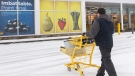 A man pushes a shopping cart towards a closed grocery store in Montreal, Sunday, Jan. 9, 2022. THE CANADIAN PRESS/Graham Hughes
